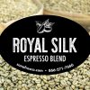 Royal Silk Espresso Blend label displayed in front of bags of green coffee beans.